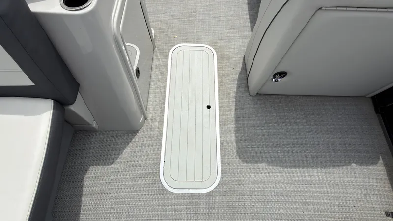 Slide: The Image of Floor area of a 2025 Starcraft EXS 3 FD TT with gray carpet and storage hatch. - 25