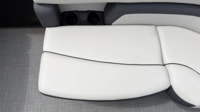Slide: The Image of The image shows a white cushioned bench with gray accents and two cup holders. - 15