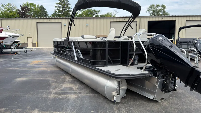 Slide: The Image of 2025 Starcraft EXS 3 FD TT pontoon boat with black railing and outboard motor. - 4