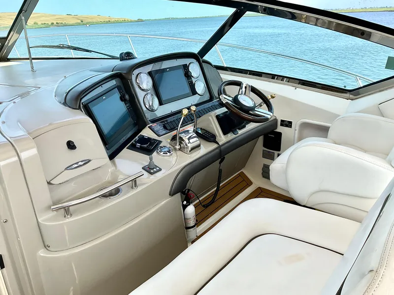 Slide: The Image of 2007 Sea Ray 38 Sundancer helm with modern controls and scenic water view. - 10