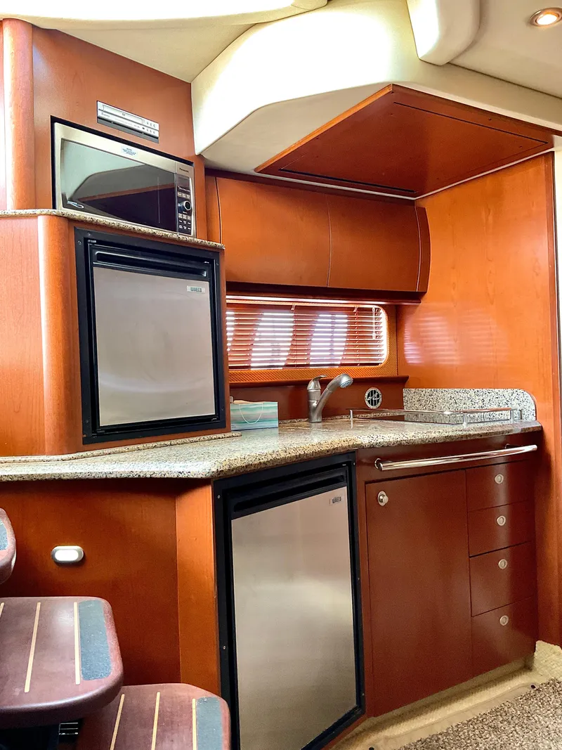 Slide: The Image of 2007 Sea Ray 38 Sundancer yacht interior kitchen with wood cabinetry and modern appliances. - 15