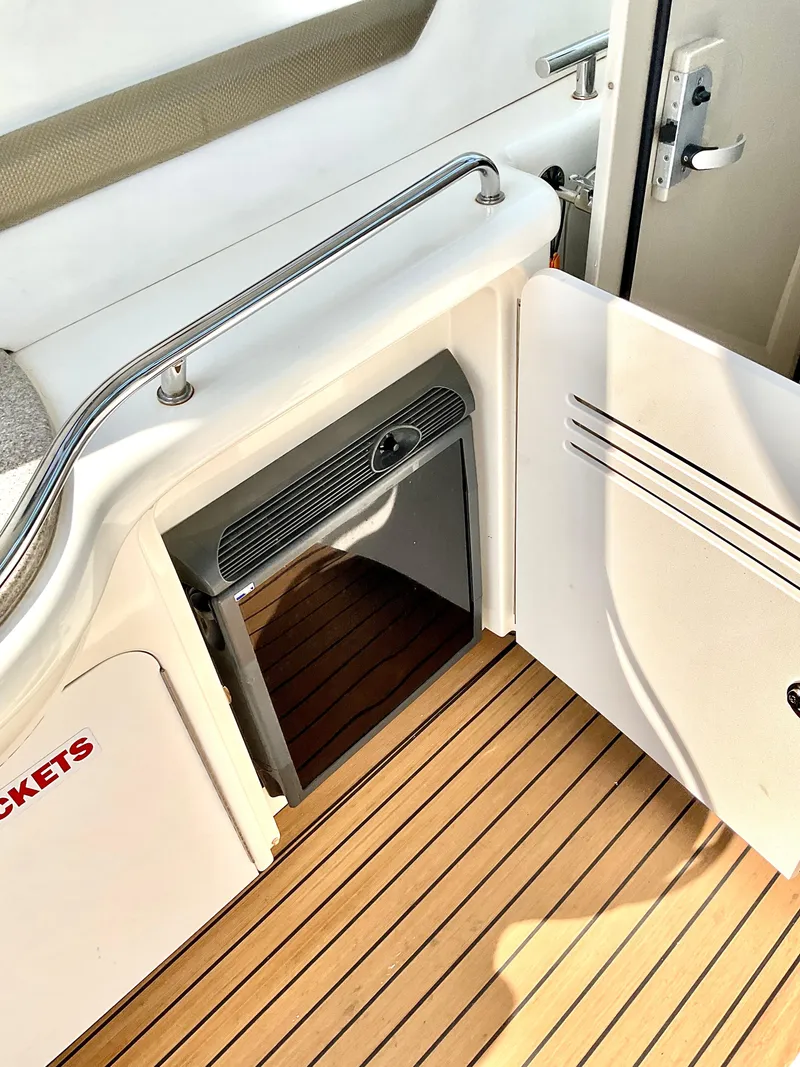 Slide: The Image of 2007 Sea Ray 38 Sundancer interior with open cabinet and wooden flooring. - 9