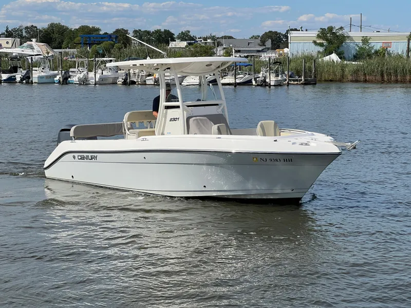 Slide: The Image of 2020 Century 2301 Center Console boat on calm water near marina. - 11