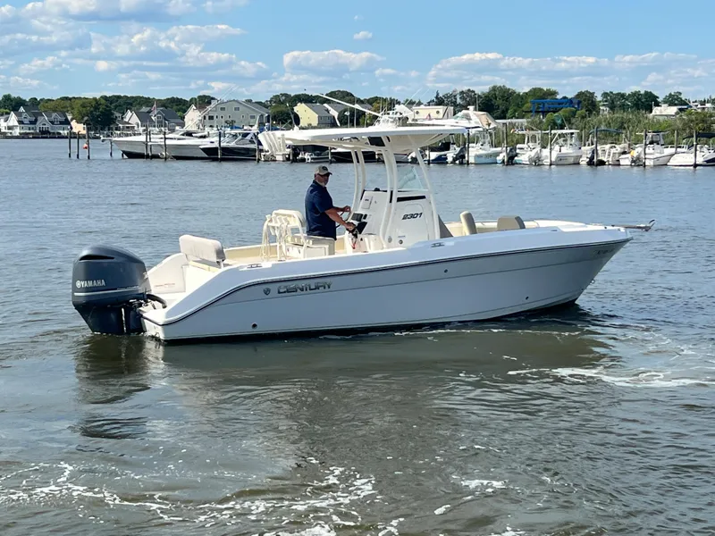 Slide: The Image of 2020 Century 2301 Center Console boat cruising on a calm river under a clear sky. - 2