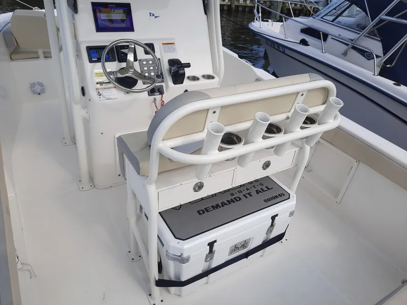 Slide: The Image of Century 2301 Center Console 2020 boat interior with steering wheel and rod holders. - 20