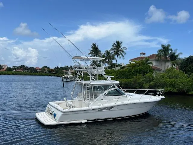 Slide: The Image of 2003 Tiara Yachts 3800 Open on a serene waterway, surrounded by lush greenery. - 16