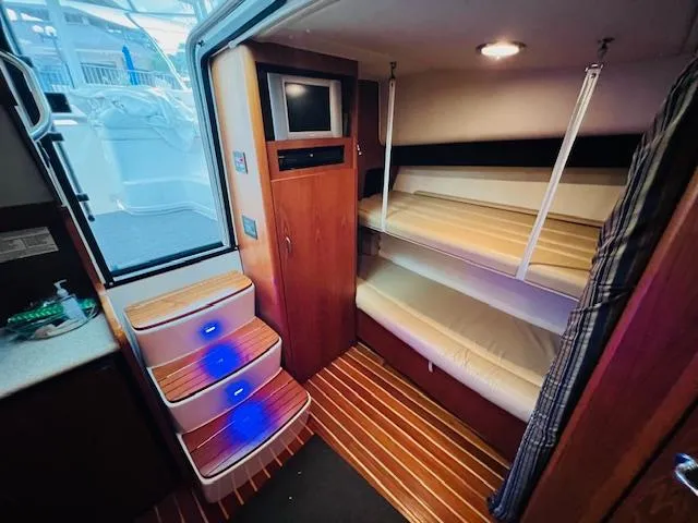 Slide: The Image of Interior of 2003 Tiara Yachts 3800 Open with bunk beds and illuminated steps. - 46