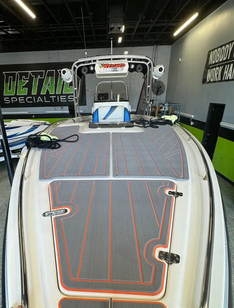 Slide: The Image of 1999 Wellcraft Scarab 302 boat in showroom, featuring sleek design and modern detailing. - 4
