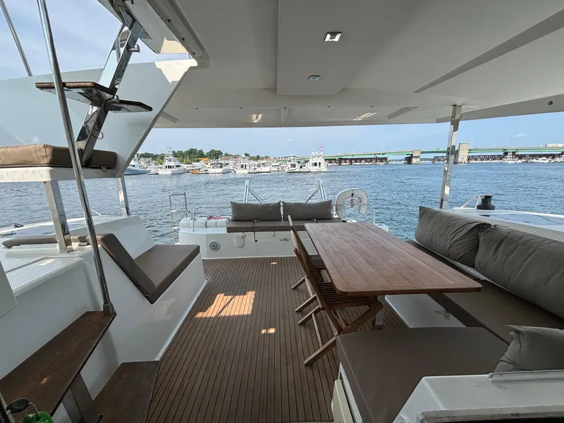 Slide: The Image of Spacious deck of 2019 Fountaine Pajot Lucia 40 catamaran with seating and table, overlooking marina. - 38