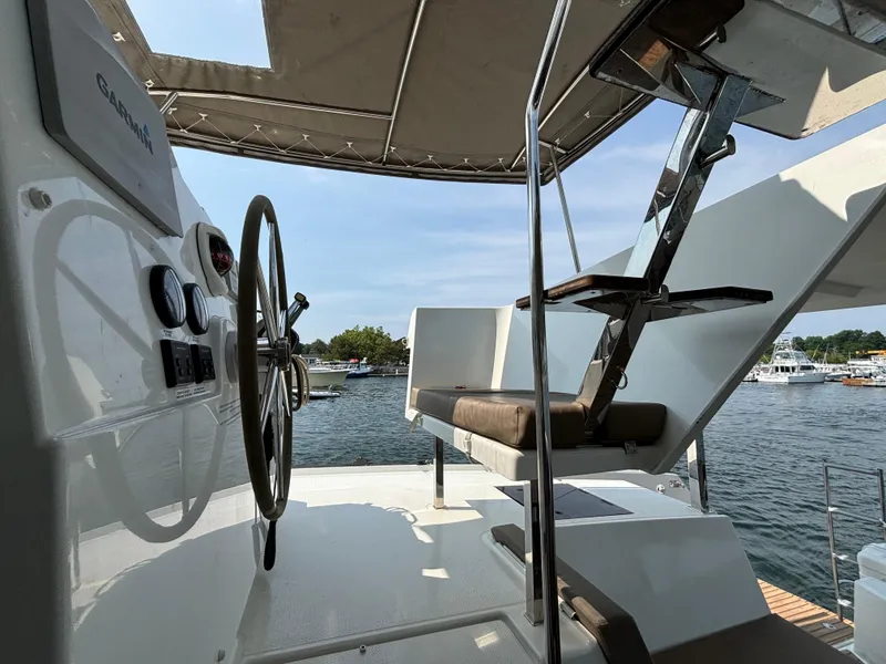 Slide: The Image of 2019 Fountaine Pajot Lucia 40 yacht helm with scenic marina view. - 40