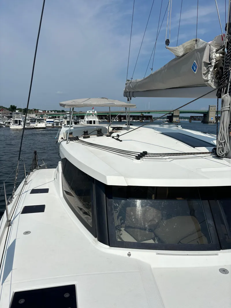 Slide: The Image of 2019 Fountaine Pajot Lucia 40 catamaran docked in a marina under a clear sky. - 47