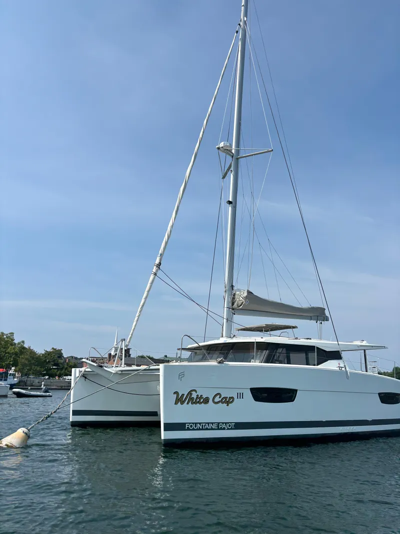 Slide: The Image of 2019 Fountaine Pajot Lucia 40 catamaran on calm water under clear sky. - 6