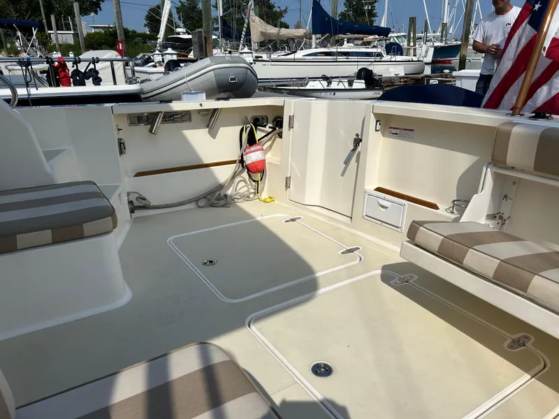 Slide: The Image of 2009 Sabre Hardtop Express boat interior with seating and storage, docked at marina. - 10