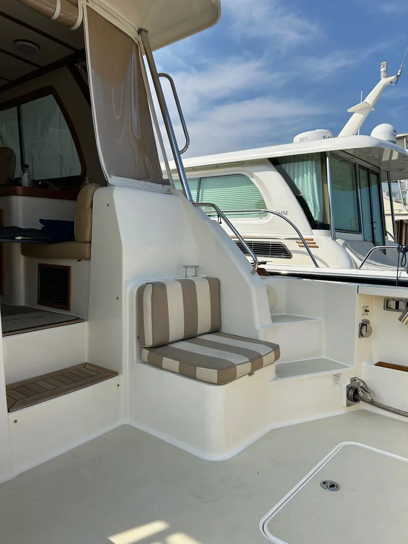 Slide: The Image of 2009 Sabre Hardtop Express boat interior with striped seating and steps. - 12