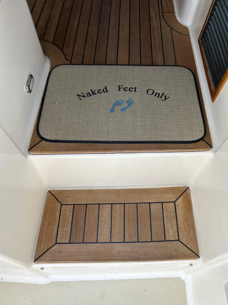 Slide: The Image of 2009 Sabre Hardtop Express interior with "Naked Feet Only" mat on wooden floor. - 13