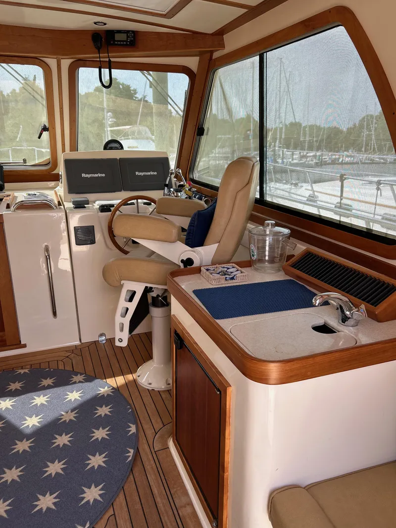 Slide: The Image of 2009 Sabre Hardtop Express interior with helm, seating, and nautical decor. - 16