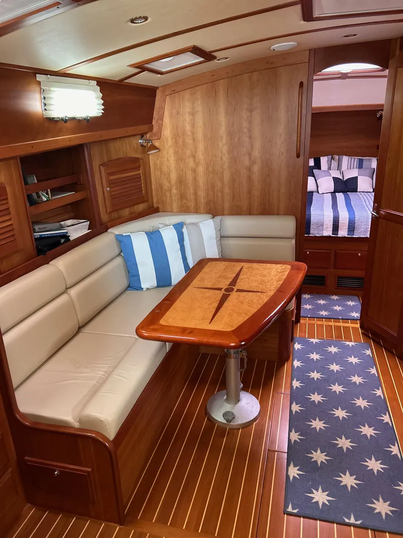 Slide: The Image of 2009 Sabre Hardtop Express interior with wood finish, cushioned seating, and nautical decor. - 22