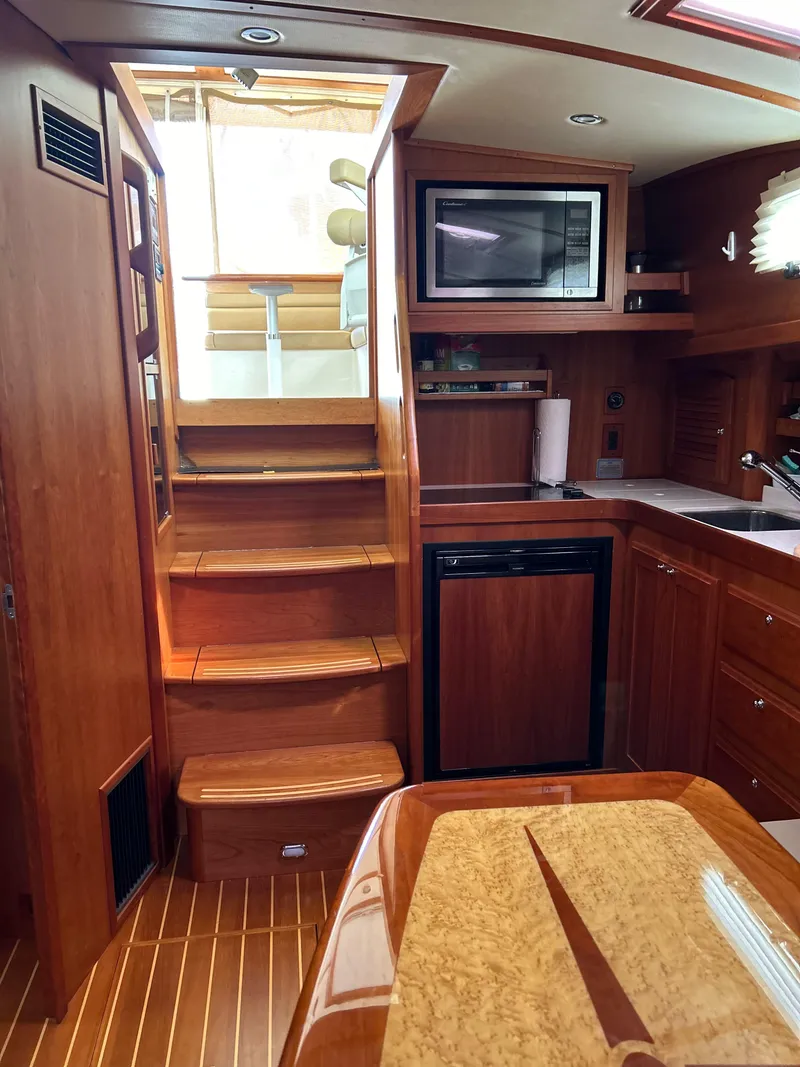 Slide: The Image of 2009 Sabre Hardtop Express interior with wooden cabinetry, stairs, and kitchen appliances. - 23