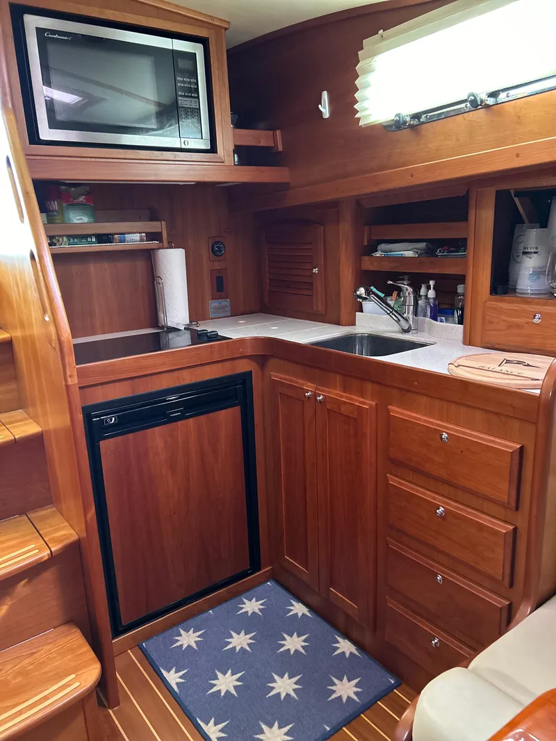 Slide: The Image of 2009 Sabre Hardtop Express yacht kitchen with wood cabinetry, microwave, and compact appliances. - 29