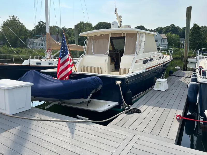 Slide: The Image of 2009 Sabre Hardtop Express yacht docked with American flag, surrounded by other boats. - 3