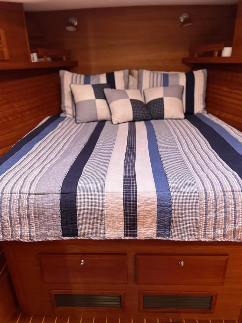 Slide: The Image of Cozy cabin bed in 2009 Sabre Hardtop Express with striped bedding and pillows. - 31