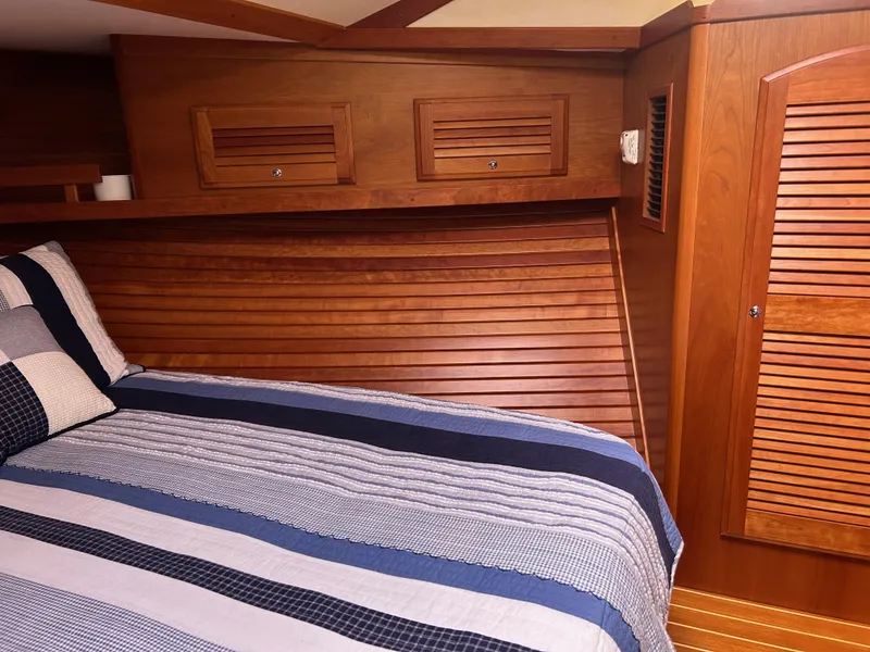 Slide: The Image of 2009 Sabre Hardtop Express cabin with wooden interior and striped bedding. - 32