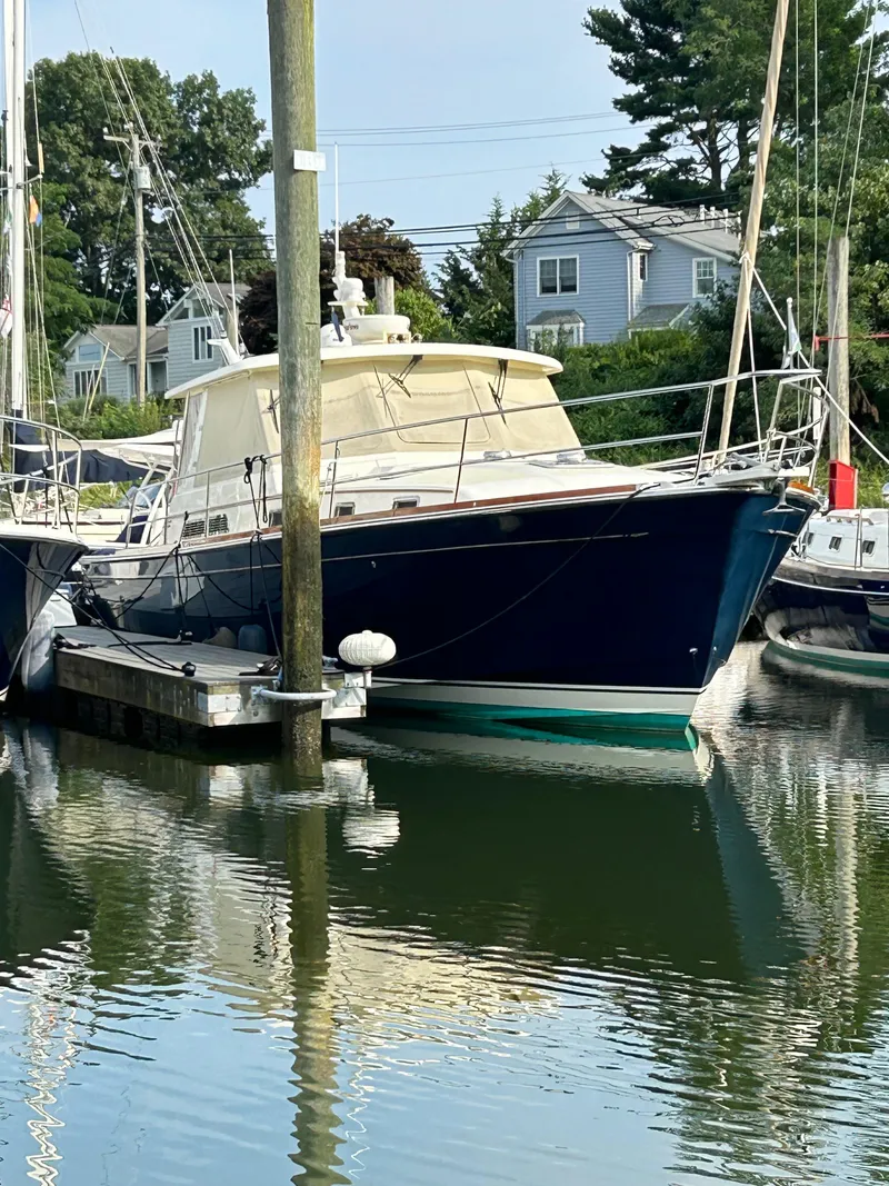 Slide: The Image of 2009 Sabre Hardtop Express boat docked in a marina, reflecting on calm water. - 4