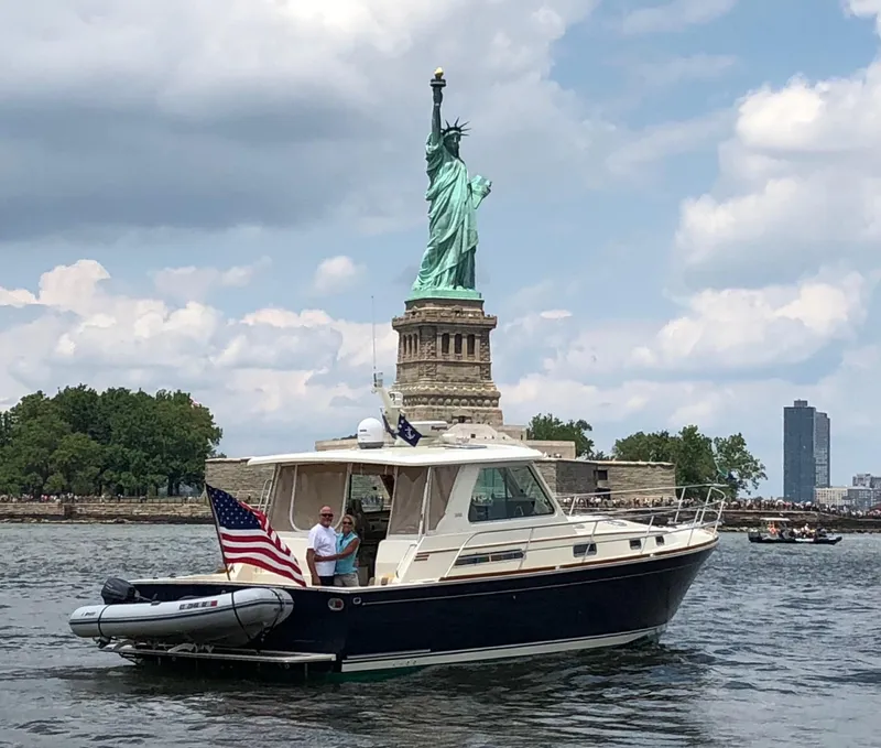 Slide: The Image of 2009 Sabre Hardtop Express boat near Statue of Liberty, flying American flag. - 46