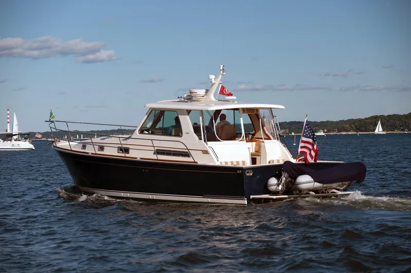 Slide: The Image of 2009 Sabre Hardtop Express boat cruising on a sunny day with American flag. - 48
