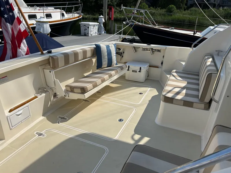 Slide: The Image of 2009 Sabre Hardtop Express boat interior with striped seating and cooler on deck. - 7