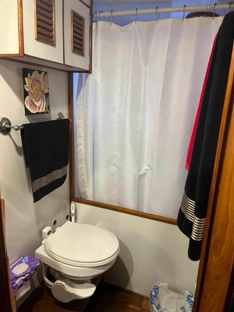 Slide: The Image of 1978 Marine Trader 44 Aft Cabin bathroom with shower, toilet, and towels. - 10