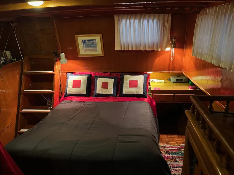 Slide: The Image of Cozy 1978 Marine Trader 44 Aft Cabin bedroom with wood paneling and decorative pillows. - 9
