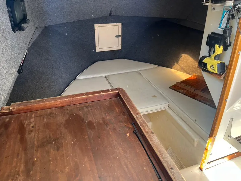 Slide: The Image of 1994 Parker 2520 boat cabin interior with wooden flooring and cushioned seating. - 15