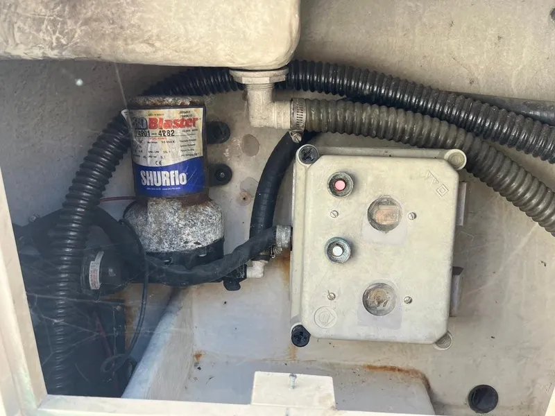 Slide: The Image of Electrical components inside a 1994 Parker 2520 boat, featuring wiring and a Shurflo pump. - 18