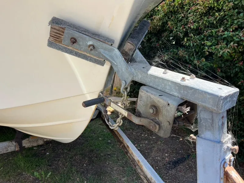 Slide: The Image of 1994 Parker 2520 boat on trailer with visible winch and cobwebs. - 20