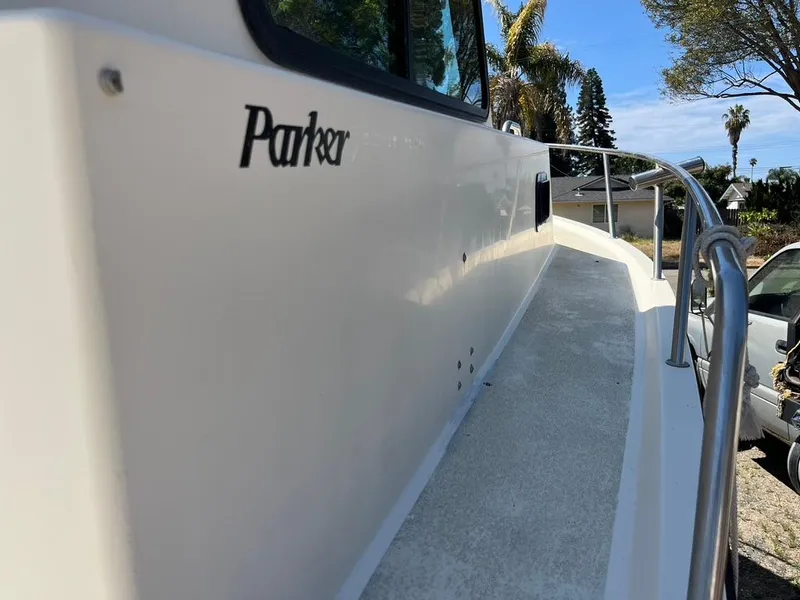 Slide: The Image of 1994 Parker 2520 boat side view with railing and logo, outdoors. - 22