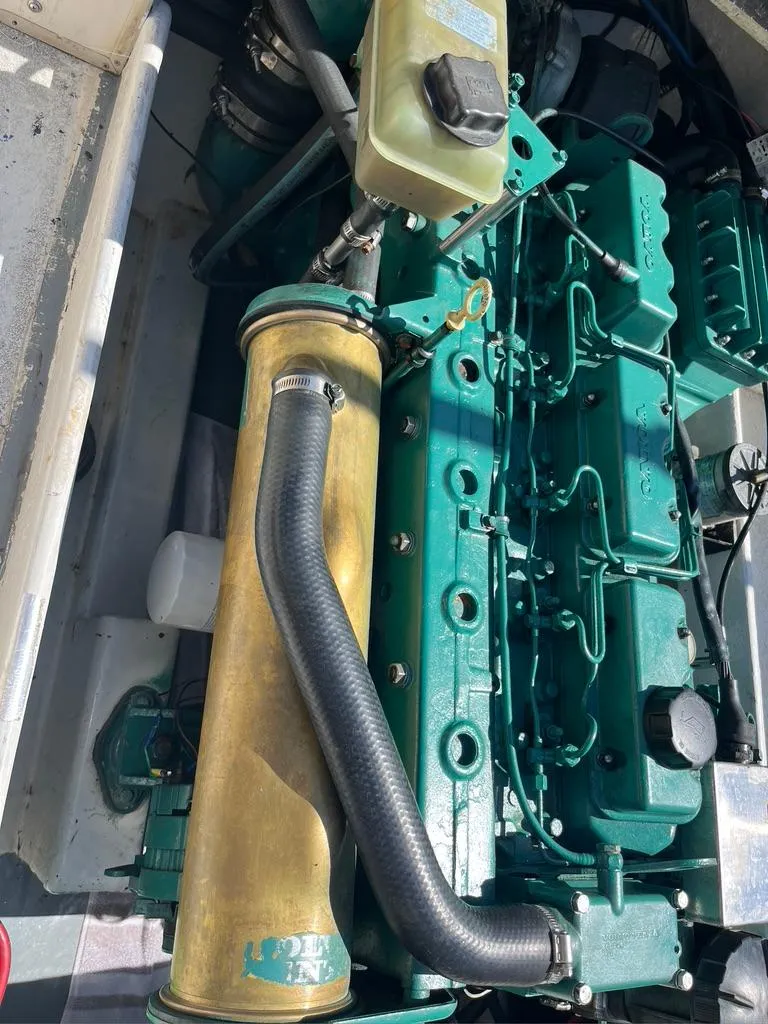 Slide: The Image of Engine of a 1994 Parker 2520 boat, featuring green components and a prominent exhaust pipe. - 26