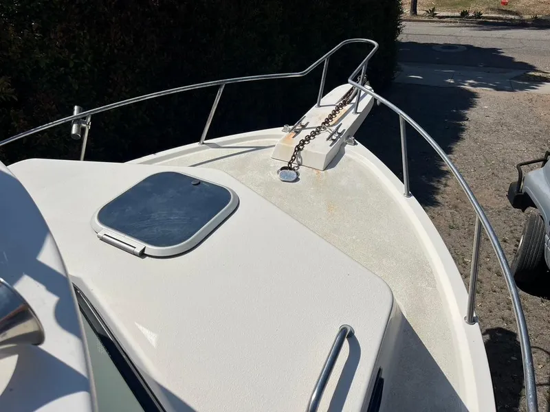 Slide: The Image of 1994 Parker 2520 boat deck with anchor chain and hatch, docked outdoors. - 3