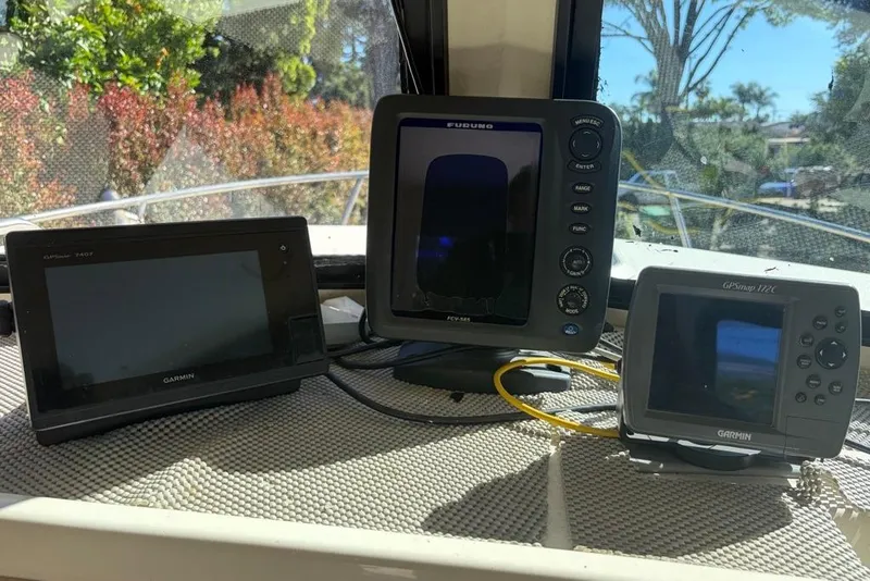 Slide: The Image of Marine electronics on a 1994 Parker 2520 boat dashboard, featuring Garmin and Furuno devices. - 32