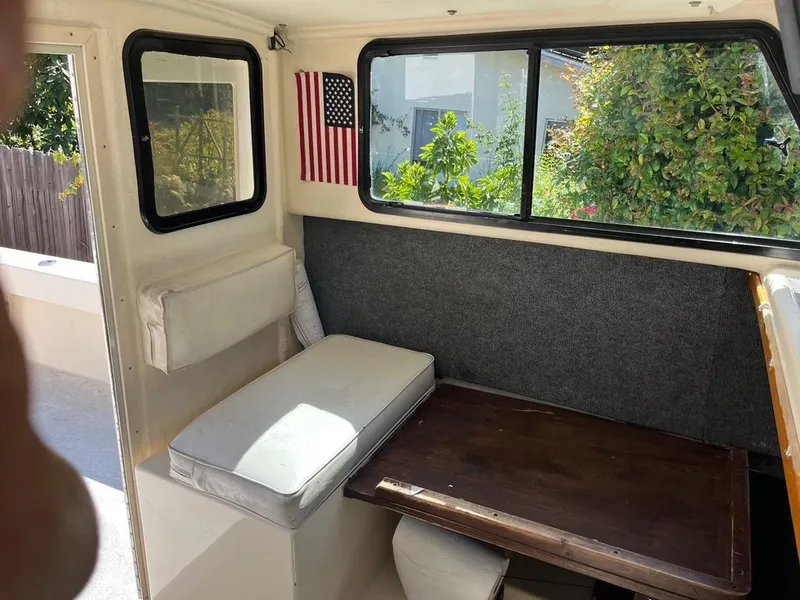 Slide: The Image of Interior of a 1994 Parker 2520 boat with seating, table, and American flag. - 36