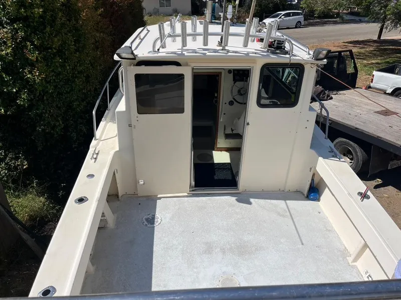 Slide: The Image of 1994 Parker 2520 boat with open deck and cabin, docked outdoors. - 7