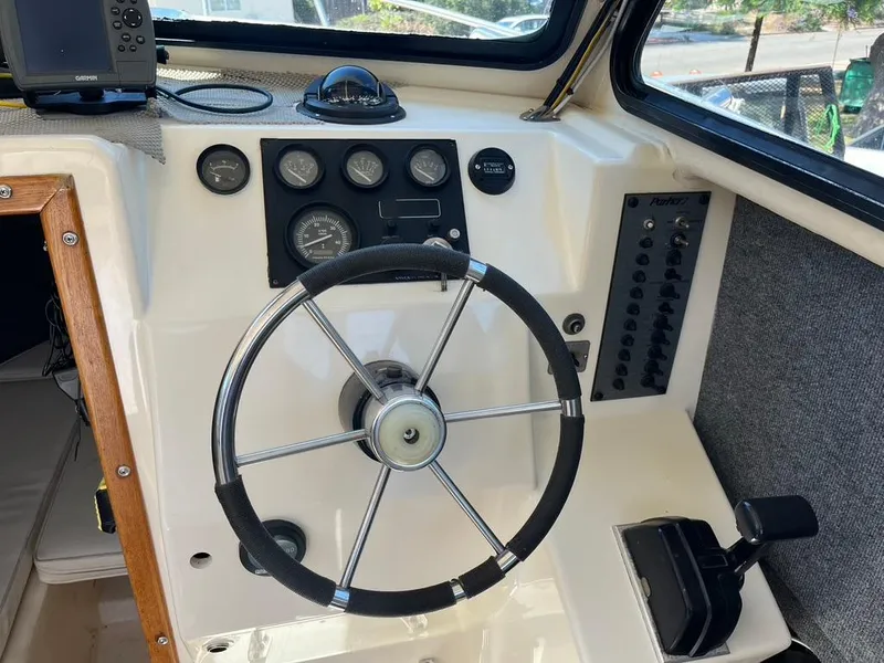 Slide: The Image of 1994 Parker 2520 boat dashboard with steering wheel and control panel. - 9
