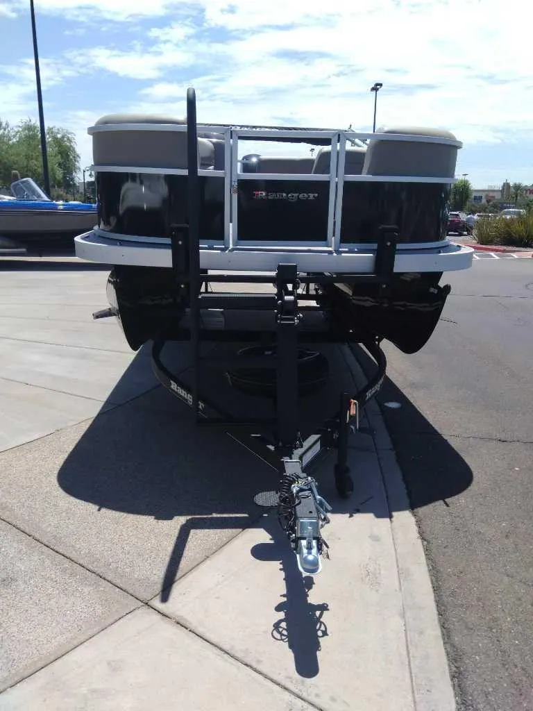 Slide: The Image of 2024 Ranger Reata 200C boat on trailer, parked on concrete surface. - 2