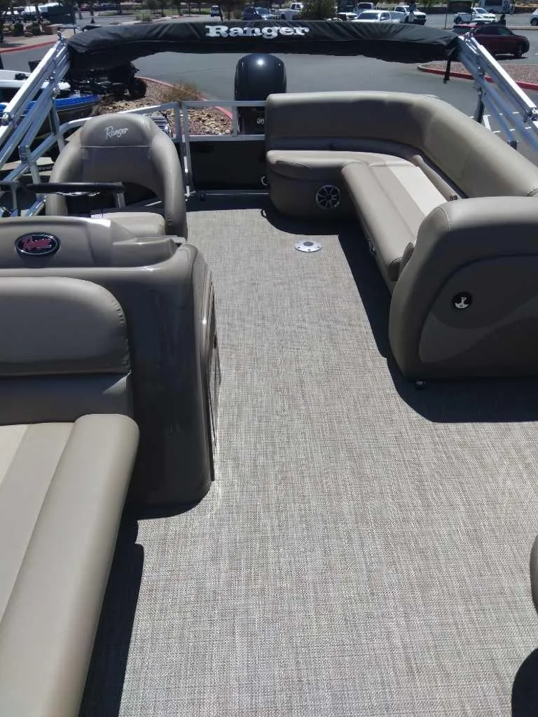 Slide: The Image of 2024 Ranger Reata 200C pontoon boat interior with beige seating and carpeted floor. - 3