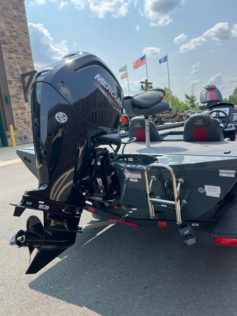 Slide: The Image of 2024 Ranger RT188C boat with Mercury outboard motor, parked outdoors under a sunny sky. - 2