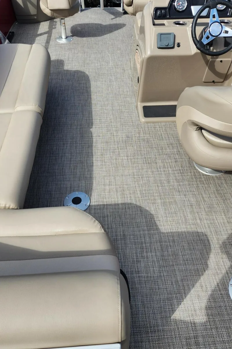 Slide: The Image of 2024 Ranger Reata 200F boat interior with beige seating and carpet flooring. - 11
