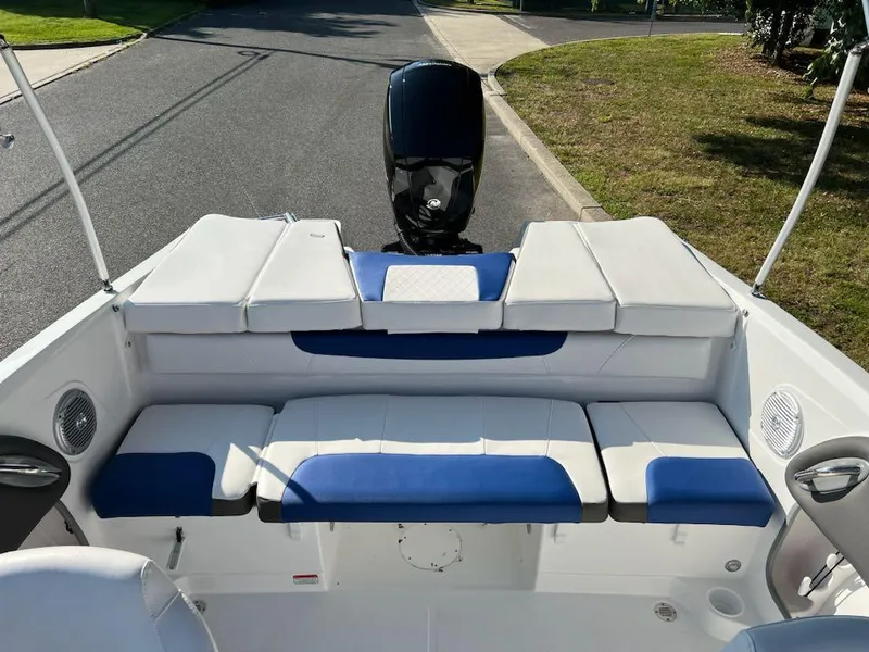 Slide: The Image of 2024 Tahoe 200 S boat interior with blue and white seating, parked on a street. - 10