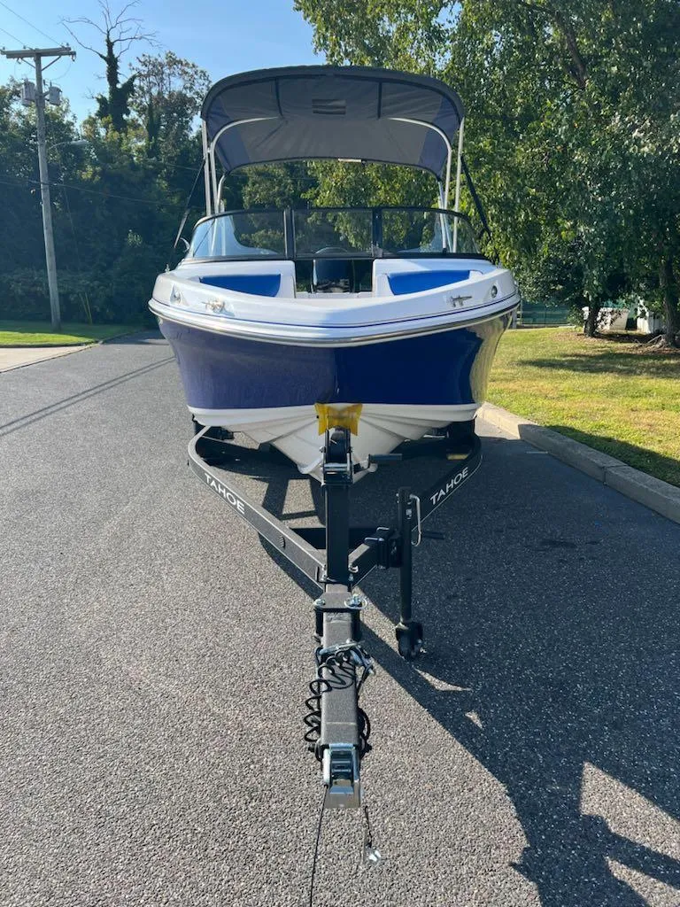 Slide: The Image of 2024 Tahoe 200 S boat on trailer, parked on sunny street. - 2