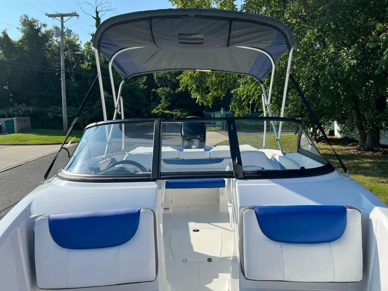 Slide: The Image of 2024 Tahoe 200 S boat with blue and white seating, bimini top, and windshield. - 6