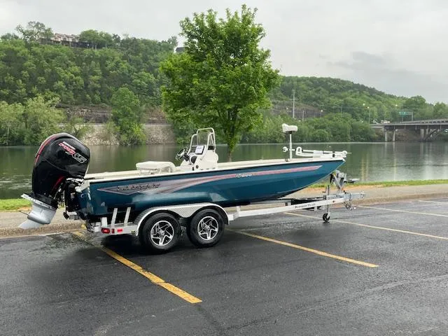 Slide: The Image of 2024 Ranger RB200 boat on trailer by a scenic riverside parking lot. - 0